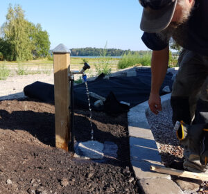 En vattenpost utdragen till rabatten istället för på husväggen.