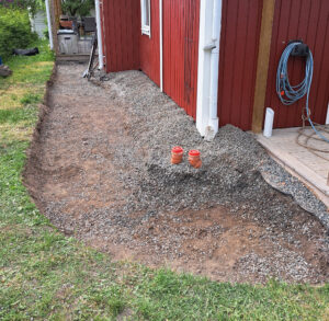 Vi gräver för grusgång. Det gick inte in en minigrävare här. Markduk och packat stenmjöl ligger under gruset.
